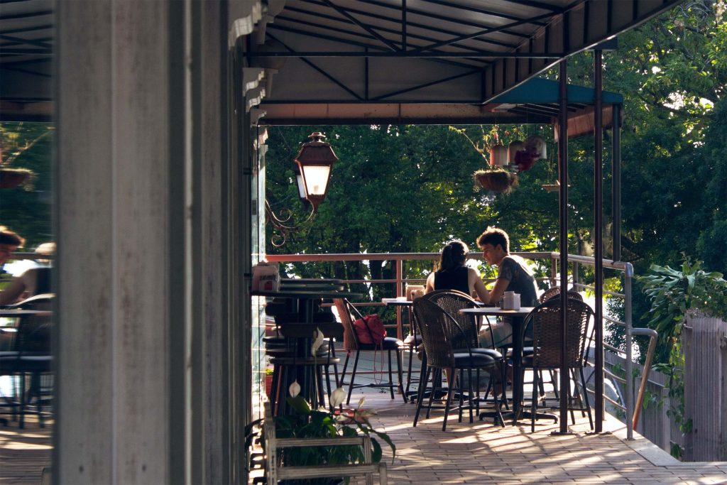 A couple sits at a table on the patio of a restaurant as they practice communication and intimacy skills learned in Couples Therapy in Pasadena, CA.